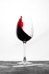 Red wine in the glass splashes in motion on a white background. Stylish design drink card