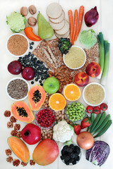 High fibre health food concept with vegetables, fruit whole grain crackers, seeds, nuts, grains & pulses. Foods with omega 3, antioxidants, anthocyanins, vitamins & minerals. Top view on  rustic wood.