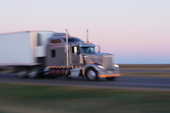 A large 18 wheeler truck on the move, blurred motion