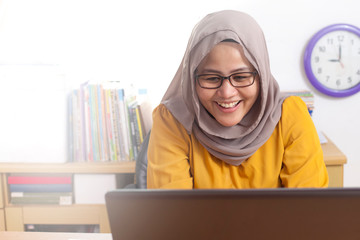 Happy, Cheerful Muslim Businesswoman Working on Laptop at the Office