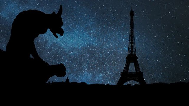 Paris: Gargoyle or chimera on the Gothic Cathedral of Notre Dame looks at the Eiffel Tower and city Skyline by Night with Stars, France. Gargoyles are old demon statue in French Culture