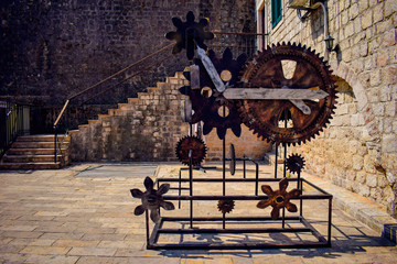 Vintage rusty clock mechanism consists of gearwheels, cogwheels,  clock hands in Medieval town...