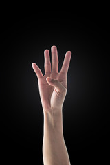 Hand up with four fingers of woman with rim light isolated on dark black background (clipping path) for number 4