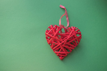 Wicker red heart on green background. Valentine's Day