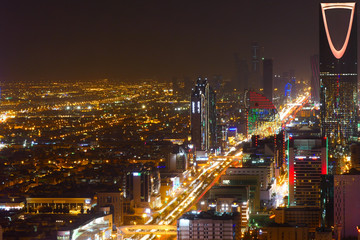 Fototapeta na wymiar Panorama view to the skyline of Riyadh by night, with the Kingdom centre in the background and light red lighting, the capital of Saudi Arabia