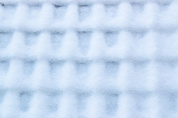    Winter texture background concept: snow-covered roof tiles on the roof of the house.