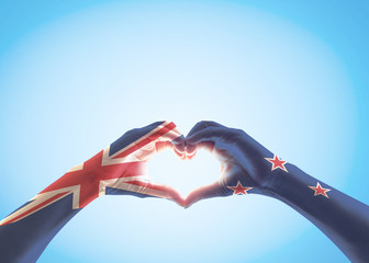 New Zealand flag pattern on people hands in heart shaped isolated on blue sky  for NZ national public holiday celebration ...