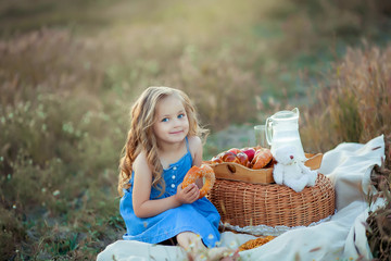 Little stylish kid wearing trendy checked shirt and jeans is having fun on the picnic. He is drinking yogurt and has milk moustache over his mouth. Dairy products concept. Outdoor shot. Copy-space.