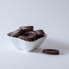 Fèves de chocolat dans une coupelle blanche