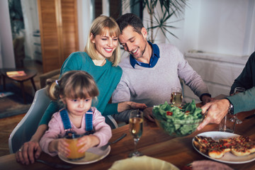 Happy family having meal in kitchen at home