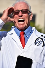 Senior Male Doctor Under Stress Wearing Lab Coat At Hospital