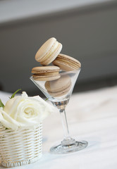 White and cream milk cheese macarons in wine glass with white rose flower