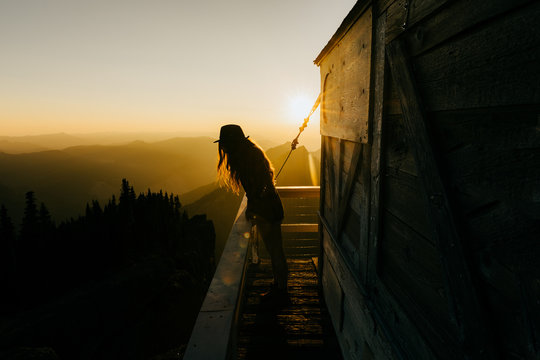Person standing on balcony during sunset