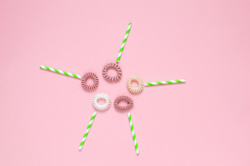 Flowers from hair spiral scrunchies on pink background, creative spring concept, flat lay, woman's day