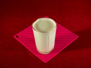 Yogurt in a glass figured glass on a red hum noise.