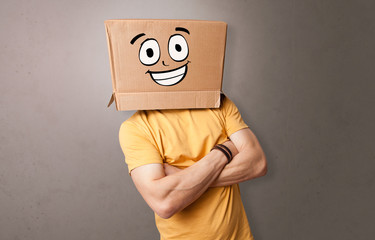 Young boy standing and gesturing with a cardboard box on his head
