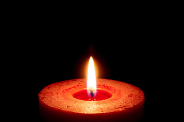 burning candle on black background