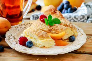 Delicious puff pastry cakes filled with cheese and fruits.