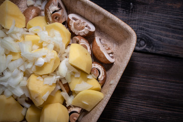 Simply, fast and tasty vegetarian dish from potato, brown champignon mushroom and onion with spices, ready for baking.
