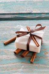 Bar of cinnamon handmade soap and cinnamon sticks.