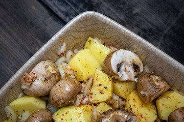 Simply, fast and tasty vegetarian dish from potato, brown champignon mushroom and onion with spices, ready for baking.