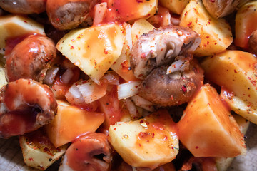 Simply, fast and tasty vegetarian dish from potato, brown champignon mushroom and onion with spices, ready for baking.