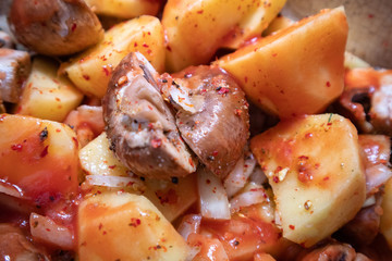 Simply, fast and tasty vegetarian dish from potato, brown champignon mushroom and onion with spices, ready for baking.