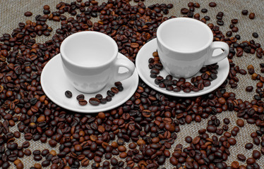 Coffee beans. Coffee cup on coffee beans. Coffee beans on burlap