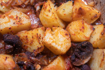 Simply, fast and tasty vegetarian dish from potato, brown champignon mushroom and onion with spices, ready for baking.