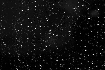 Droplets of water on black glass background