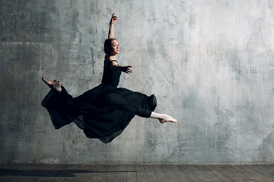 Ballerina female. Young beautiful woman ballet dancer, dressed in professional outfit, pointe shoes and black dress.