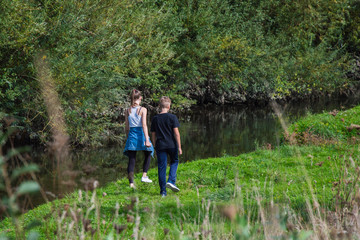 Fototapeta na wymiar children walk in nature, along the pond
