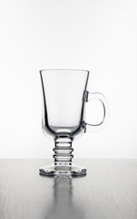Empty glass cup in backlight on a white background