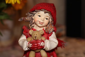 German girl toy in red hat with bear