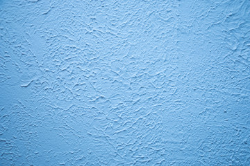 Blue textured wall. Decorative plastering close-up photo. Surface with stucco daub