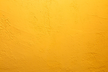 Yellow textured wall. Decorative plastering close-up photo. Surface with stucco daub