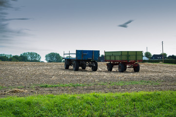 blue and green field truck on an empty field.trailer tractor on the harvested field, harvesting.