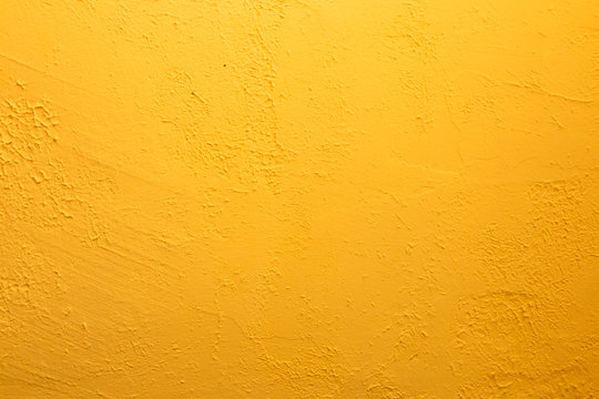 Yellow textured wall. Decorative plastering close-up photo. Surface with stucco daub