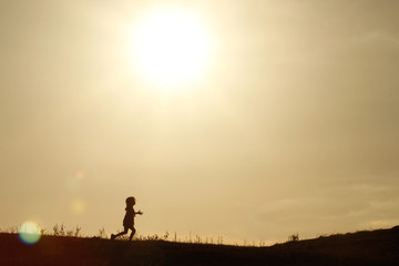 Criança correndo silhueta por do sol