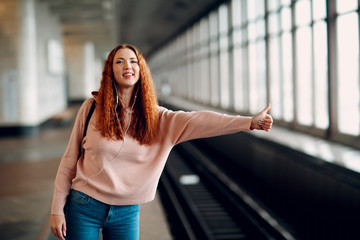 Positive redhead young female stops subway train