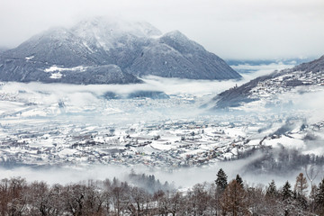 Cold foggy winter day in Valsugana, Sugana Valley, seen from Strigno, located at the Alps’ foothills in Trentino, Italy. Mystic landscape of the Dolomite mountains.