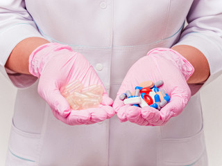 Placebo drugs concept. Doctor holds pills and placebo's. Hand in pink Gloves with Pills. Empty pills. Healthcare concept - obrazy, fototapety, plakaty