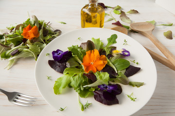 Lettuce and flower salad on woody white background spring, easter