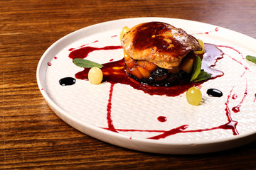 dish of fuagra decorated on black wood table background 