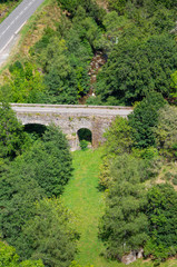 Fototapeta na wymiar Small stone bridge on the Lot towards Saint-Julien-du-Tournel, Lozere, Occitanie.