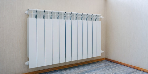 Radiator heating, white radiator in the apartment. Hand felt the coldness. Heating is turned off...
