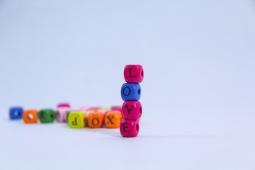 Love alphabet written on colourful stack wooden block with white background