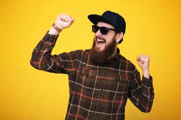 Fototapeta na wymiar Close up portrait of ecstatic handsome bearded man celebrating with arms outstretched