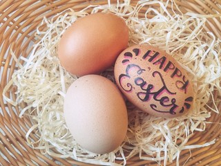 Handlettered eggs in a wicker basket for Easter celebration