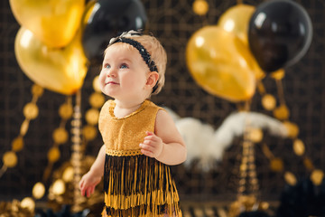One year old baby girl celebrating her first birthday eating cake